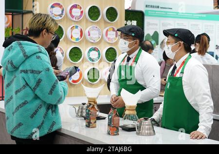 (231201) -- PEKING, 1. Dezember 2023 (Xinhua) -- Ein Besucher erfährt Kaffeeprodukte am Stand von Starbucks auf der China International Supply Chain Expo (CISCE) in Peking, Hauptstadt Chinas, 28. November 2023. Auf der laufenden China International Supply Chain Expo (CISCE) hat der US-amerikanische Kaffeeriese Starbucks durch seine Kaffeekette und seine Produkte große Aufmerksamkeit auf sich gezogen. Starbucks kam 1999 auf das chinesische Festland und betreibt heute mehr als 6.800 Geschäfte in über 250 chinesischen Städten. 2012 wurde in Pu'er in der Provinz Yunnan ein Starbucks Farmer Support Center gegründet, das erste von ITS Stockfoto