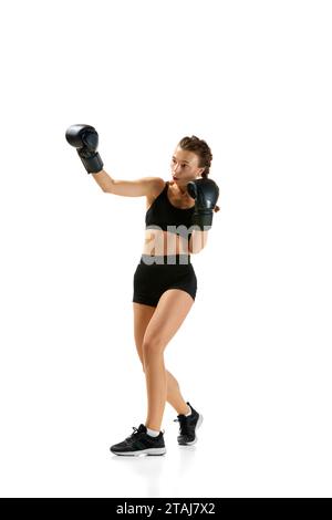 Wildes und selbstbewusstes, entschlossenes Boxermädchen, professioneller Sportler, posiert vor weißem Studio-Hintergrund. Das Konzept des Individualsports. Stockfoto