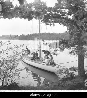 In den 1950er Jahren Eine Familie in einem Segelboot wird an einem schönen Ort entlang der schwedischen Küste vor Anker gesehen. Schweden 1954 Kristoffersson Ref. BG19-6 Stockfoto