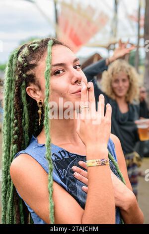 Eine junge Frau mit Dreadlocks und Gesichtspiercings posiert für die Kamera während des Ozora Festivals Stockfoto