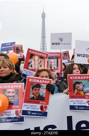 Paris, Frankreich. Dezember 2023. Französische Bewohner halten Plakate mit Porträts von Geiseln, die noch immer in Gaza gehalten werden, um ihre sofortige Freilassung während einer Kundgebung der Internationalen Zionistischen Organisation der Frauen (WIZO) vor dem Eiffelturm in Paris am Freitag, den 1. Dezember 2023 zu fordern. Die israelischen Luftangriffe nahmen heute wieder auf, als die siebentägige Pause der Kämpfe zwischen Israel und Hamas endete. Foto: Maya Vidon-White/UPI. Quelle: UPI/Alamy Live News Stockfoto