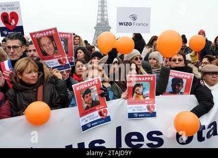 Paris, Frankreich. Dezember 2023. Französische Bewohner halten Plakate mit Porträts von Geiseln, die noch immer in Gaza gehalten werden, um ihre sofortige Freilassung während einer Kundgebung der Internationalen Zionistischen Organisation der Frauen (WIZO) vor dem Eiffelturm in Paris am Freitag, den 1. Dezember 2023 zu fordern. Die israelischen Luftangriffe nahmen heute wieder auf, als die siebentägige Pause der Kämpfe zwischen Israel und Hamas endete. Foto: Maya Vidon-White/UPI. Quelle: UPI/Alamy Live News Stockfoto