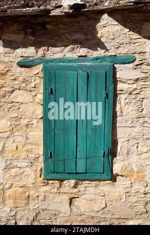 Zypern - Haus mit traditionellem Bau mit Steinen und grün lackierten Fensterläden im Bergdorf Omodos Stockfoto