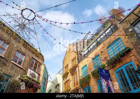 London, Großbritannien - 4. Januar 2023: Weihnachtsbeleuchtung in Neal's Yard, Covent Garden, London. Eine farbenfrohe Gasse mit Geschäften und Cafés in Seven Dials. Stockfoto