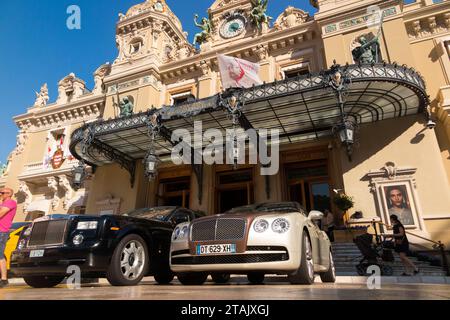 Teure Autos, Leute, die sie sehen und das Äußere von Monte Carlo / Monte-Carlo Casino, Monaco. Sonniger Sommertag mit Sonne und blauem Himmel. (135) Stockfoto