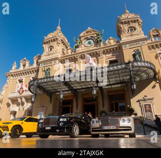 Teure Autos, Leute, die sie sehen und das Äußere von Monte Carlo / Monte-Carlo Casino, Monaco. Sonniger Sommertag mit Sonne und blauem Himmel. (135) Stockfoto