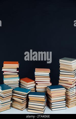 Viele Stapel alter Lehrbücher in einer Bibliothek mit schwarzem Hintergrund Stockfoto