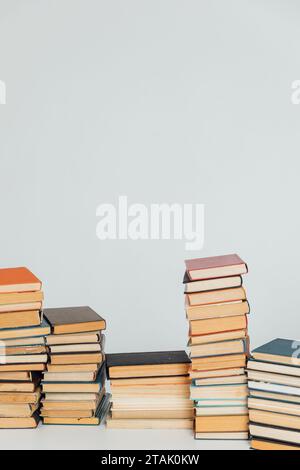 Viele Stapel alter Lehrbücher in der Universitätsbibliothek mit weißem Hintergrund Stockfoto