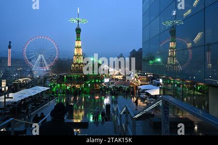 Stuttgart, Deutschland. Dezember 2023. Eine beleuchtete Weihnachtspyramide spiegelt sich in einer Glasfassade am Stuttgarter Schlossplatz wider. Quelle: Bernd Weißbrod/dpa/Alamy Live News Stockfoto