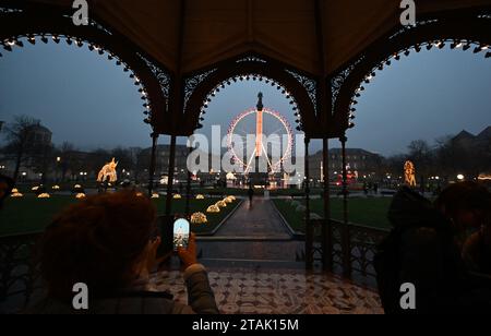 Stuttgart, Deutschland. Dezember 2023. Ein beleuchtetes Riesenrad leuchtet in der Dämmerung auf dem Schlossplatz in Stuttgart. Quelle: Bernd Weißbrod/dpa/Alamy Live News Stockfoto