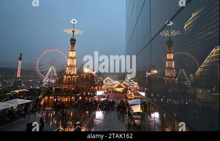 Stuttgart, Deutschland. Dezember 2023. Eine beleuchtete Weihnachtspyramide spiegelt sich in einer Glasfassade am Stuttgarter Schlossplatz wider. Quelle: Bernd Weißbrod/dpa/Alamy Live News Stockfoto