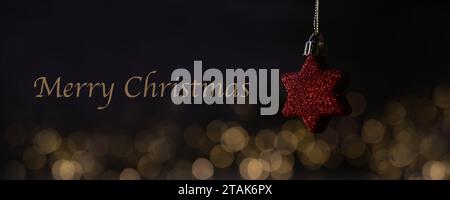 Rote Weihnachtsdekoration mit Chrismas-Lichtern und frohe Weihnachten-Text, Kopierraum Stockfoto