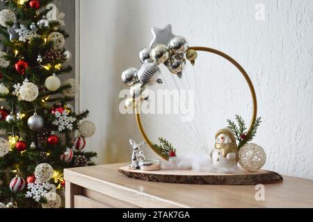 Handgefertigte Weihnachtsdekoration. Weihnachtskonzept. Schneemann hält Kugeln als Ballons. Stockfoto