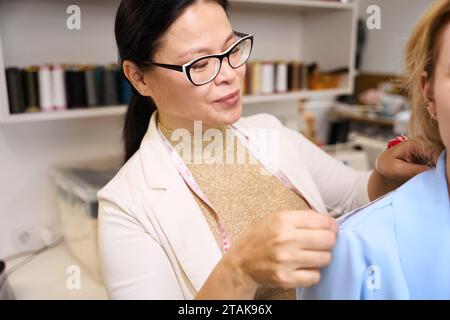 Näherin verwendet beim Anbringen Maßband Stockfoto