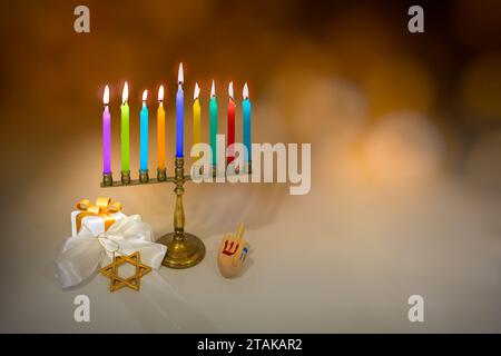 Jüdischer Feiertag Hanukka Hintergrund mit Menora (traditionelle Kandelaber), Kerzen, Dreidel (drehbare Spitze), Stern von David, Geschenkbox. Verschwommener Bokeh-Rücken Stockfoto