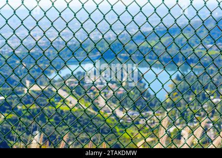 Diamantgitter-Zaun und unscharfer Blick auf das malerische Hollywood Reservoir in Los Angeles. Stockfoto