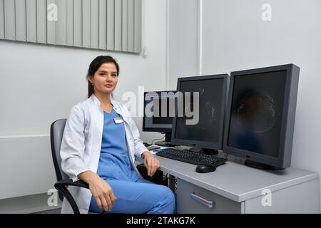 Aufnahme einer Ärztin, die an medizinischer Expertise arbeitet, während sie vor dem Laptop am Schreibtisch sitzt Stockfoto