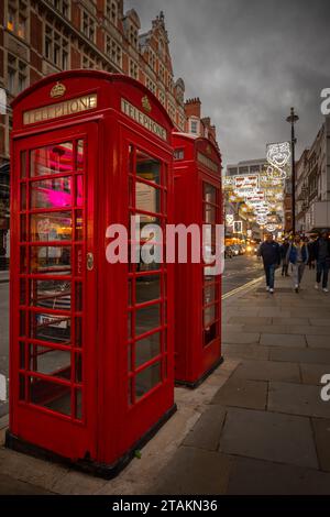 London, Großbritannien - 20. November 2023: Rote öffentliche Telefonzellen in der St Martin's Lane im Zentrum von London. Stockfoto
