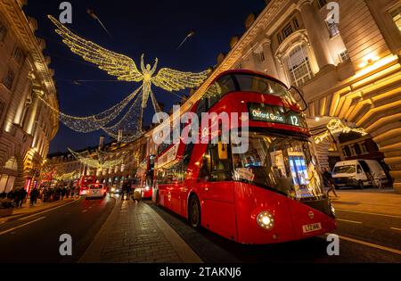 London, Großbritannien - 20. November 2023: Regent Street im Zentrum von London mit roten Bussen und Weihnachtslichtern. Die Leute sind Weihnachtseinkäufe. Stockfoto