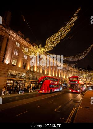 London, Großbritannien - 20. November 2023: Regent Street im Zentrum von London mit zwei roten Bussen und Weihnachtslichtern. Die Leute sind Weihnachtseinkäufe. Stockfoto