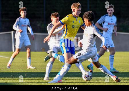 Swansea, Wales. 1. Dezember 2023. Jet Dyer von Colchester United kämpft um Besitz mit Kristian Fletcher und Sam Parker aus Swansea City während des U21 Professional Development League-Spiels zwischen Swansea City und Colchester United am 1. Dezember 2023 an der Swansea City Academy in Swansea, Wales. Quelle: Duncan Thomas/Majestic Media/Alamy Live News. Stockfoto