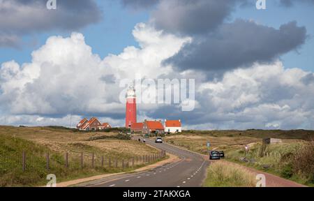 Sanddünen mit einer Straße zum Leuchtturm von Eierland unter bewölktem Himmel. Texel, Nort Holland, Niederlande, Stockfoto