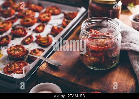 Konservierung von im Ofen gebackenen Tomaten mit Olivenöl und Kräutern In einem Glasglas Stockfoto