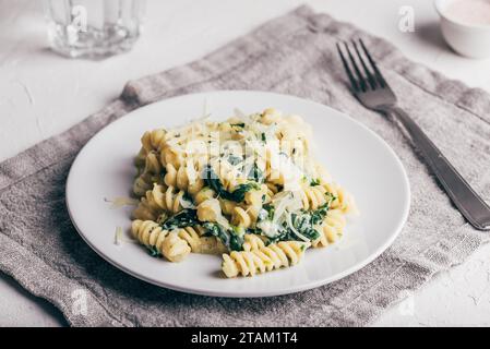 Cremige Spinat Pasta mit Ricotta und Parmesan auf weißem Teller Stockfoto