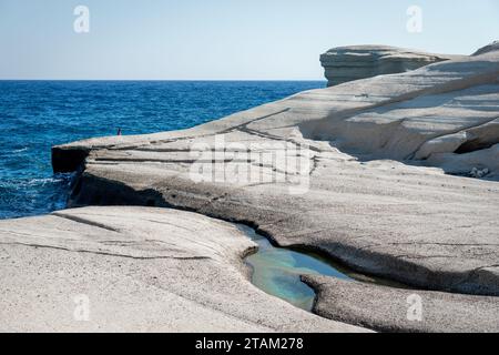 Eine malerische Landschaft mit einer großen Felswände, umgeben von kristallklarem Wasser, mit kleinen Blasen, die auf der Oberfläche schweben Stockfoto