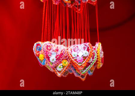 Rote herzförmige Lolly-Pops, süße Halskette auf Weihnachtsmärkten sind traditionelle Souvenir-Essgeschenke, Details Stockfoto