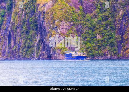 Touristische Kreuzfahrt Schiff auf dem Milford Sound Waters bei Stirling Falls im Fiordland von Neuseeland. Stockfoto