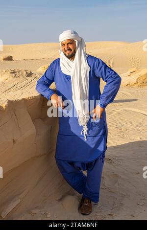 Nafta, Tozeur, Tunesien. März 2023. Tunesischer Mann mit blauem Thaab in der Wüste. Stockfoto