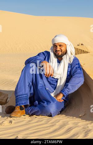 Nafta, Tozeur, Tunesien. März 2023. Tunesischer Mann mit blauem Thaab in der Wüste. Stockfoto