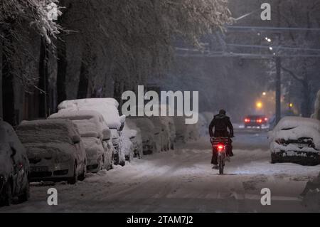 München, Deutschland. Dezember 2023. Ein Mann fährt mit dem Fahrrad über eine schneebedeckte Straße. Quelle: Sven Hoppe/dpa/Alamy Live News Stockfoto