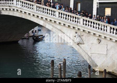 Massentourismus in Venedig, während sich zahlreiche Touristen auf der Balustrade der Rialto-Brücke tummeln, um ein Bild vom Canal Grande, Gondeln, Venedig, Italien, zu machen Stockfoto