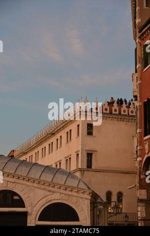 Vom Dachbalkon Fondaco dei Tedeschi 'Altane' bei Sonnenuntergang haben Touristen einen Blick auf die Rialtobrücke und den Canal Grande auf die Skyline von Venedig Stockfoto