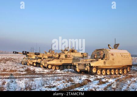 Eiserner Donner! Gepanzerte Feldartilleriewege, die der Bravo-Batterie, 4. Bataillon, 27. Feldartillerie-Regiment, 2. Panzerbrigade Combat Team, 1. Panzerdivision, zugewiesen sind, stehen am 1. Dezember 2023 während des US-polnischen MARS 23 LFX in Toruñ, Polen, ausgerichtet. Die Übung beinhaltete mehrere Paladin M109 Artilleriesysteme und beinhaltete sogar Luftunterstützung von zwei polnischen F-16-Kampffalken. (Foto: U.S. Army SPC. Trevares Johnson) Stockfoto