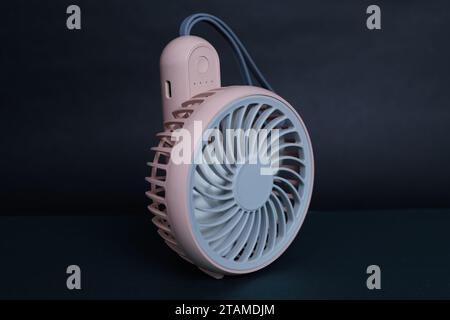 Mini elektrische pinkfarbene Pfanne, isoliert auf dunklem Hintergrund. Vorderansicht. Tragbare elektrische Geräte, die bei heißem Wetter sehr nützlich sind. Stockfoto