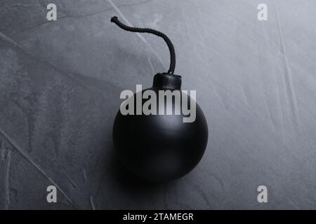 Kugelförmige Bombe mit brennender Sicherung auf schwarzem Hintergrund, Draufsicht Stockfoto