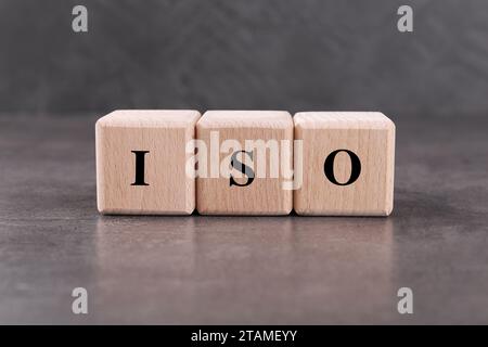 Holzwürfel mit der Abkürzung ISO auf grauem, strukturiertem Tisch Stockfoto