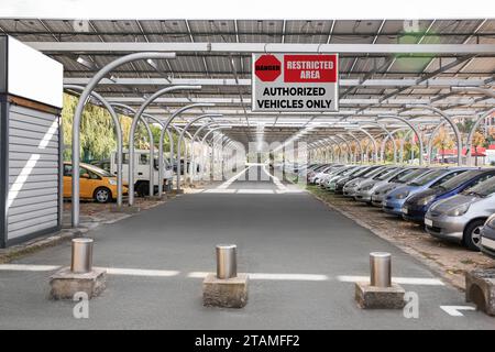 Schild mit Text „Restricted Area Authorized Vehicles“ nur in der Nähe von Parkplätzen im Freien Stockfoto