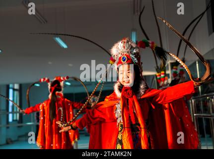 Peking, Chinas Chongqing. November 2023. Die Schüler üben den traditionellen „bian lian“, also die Gesichtsveränderung, in einem Tanzunterricht an der Wu'an Grundschule im Bezirk Dianjiang im Südwesten Chinas in Chongqing, 28. November 2023. Mit mehr als 600 Schülern kooperierte die Wu'an Grundschule in den letzten Jahren mit dem Volkskünstler Li Yong und fügte Gesichtswechsel als besonderen Teil ihres Lehrplans hinzu. Die Technik des Gesichtswechsels ist einer der berühmtesten Teile der Sichuan Opera, bei der Schauspieler schnell ihr Gesicht in atemberaubender und dramatischer Wirkung verändern. Quelle: Liu Chan/Xinhua/Alamy Live News Stockfoto