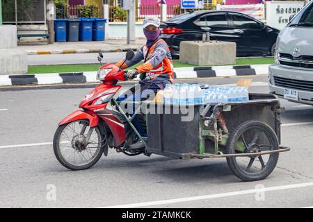 SAMUT PRAKAN, THAILAND, 11. Oktober 2023, Ein Mann fährt Motorrad mit einem beladenen Beiwagen Stockfoto