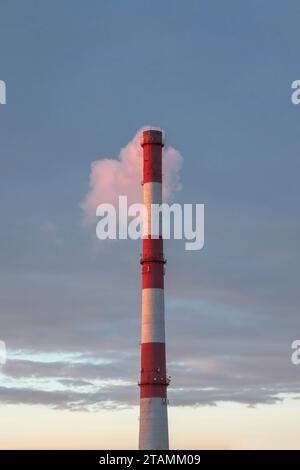 Rauchende Pfeifen, die Wolken vor dem Hintergrund des Sonnenuntergangs bilden. Luftverunreinigung durch Kohlendioxid. Umweltverschmutzung. Stockfoto