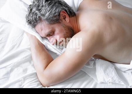 Mann schläft im Bett. Schlafen und schlafen. Schnarchen schläfriges Nickerchen wach auf. Matratzenbett. Schlaf verschlafen. Morgenschlaf. Hispanischer Mann, der im Schlafzimmer schläft Stockfoto