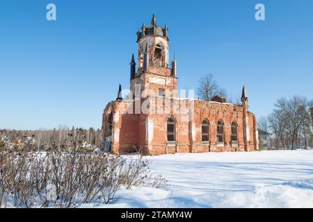 Blick auf die Ruinen der antiken orthodoxen Dreifaltigkeitskirche im Dorf Andrianovo an einem sonnigen Märztag. Anwesen „Maryino“. Leningra Stockfoto