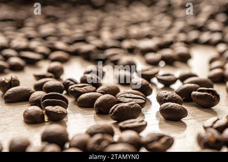 Geröstete Kaffeebohnen mit Hintergrund. Coffee Bohne Nahaufnahme auf einem Holztisch. Stockfoto