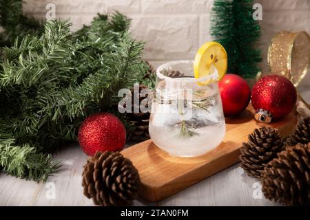 Schneekugel-Cocktail. Weihnachtsgetränk, kreatives Festgetränk im Glas, dekoriert mit Rosmarinzweig wie eine weihnachtskiefer und Zitrus sli Stockfoto