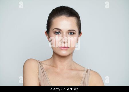 Attraktives modisches Schönheitsmodell Brünette mit klarer Haut und dunklem Haar. Schönes junges Frauengesicht Nahaufnahme Porträt Stockfoto