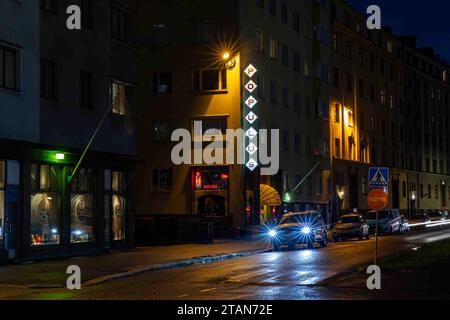 Blick auf die Straße Aleksis Kiven Katu mit Karaoke-Bar Populus nach Einbruch der Dunkelheit im Bezirk Harju in Helsinki, Finnland Stockfoto